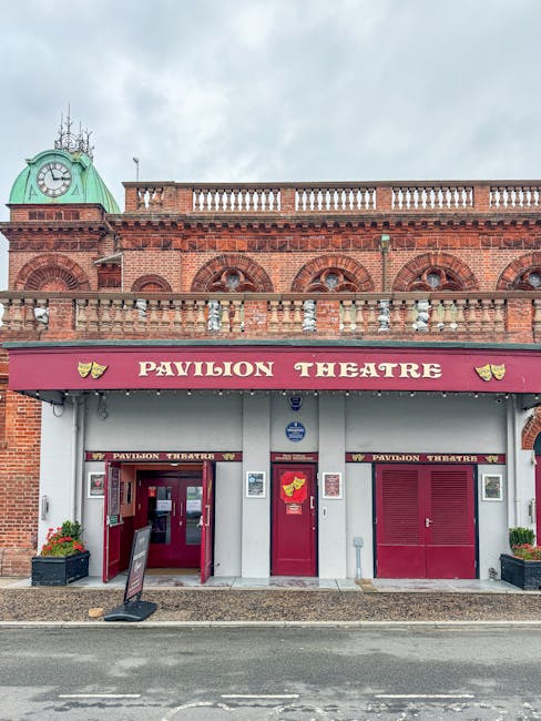 Exterior view of the Rose Theatre Kingston building with a brick facade and large, vertical windows. Above the entrance, a white marquee displays the show titles 'Captain Marvel 12A' and 'Dumbo (PG)'